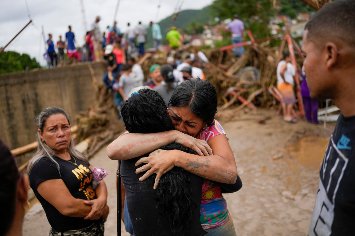 Residents embrace in Las Tejerias, Venezuela, Sunday, Oct. 9, 2022, after intense rain caused a river to overflow flooding the town. 