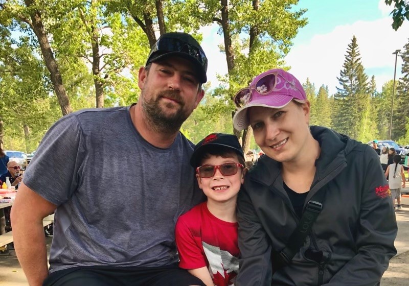 Megan Goett poses for a picture with her husband and son.