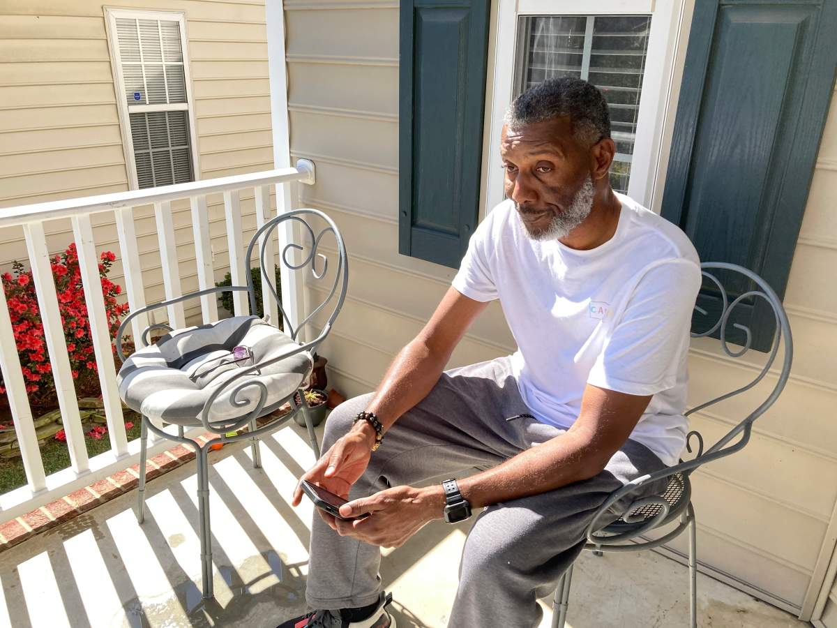 Tracey Howard, husband of Nicole Connors who was fatally shot on Thursday, Oct. 13, 2022, sits on the porch of his Raleigh, N.C., home on Friday, Oct. 14. On Thursday, a 15-year-old boy fatally shot two people in the streets of a middle-class Raleigh neighborhood, then fled toward a popular walking trail where he opened fire, killing three more people and wounding two others in an attack that left the city reeling and authorities searching for a motive, police said.