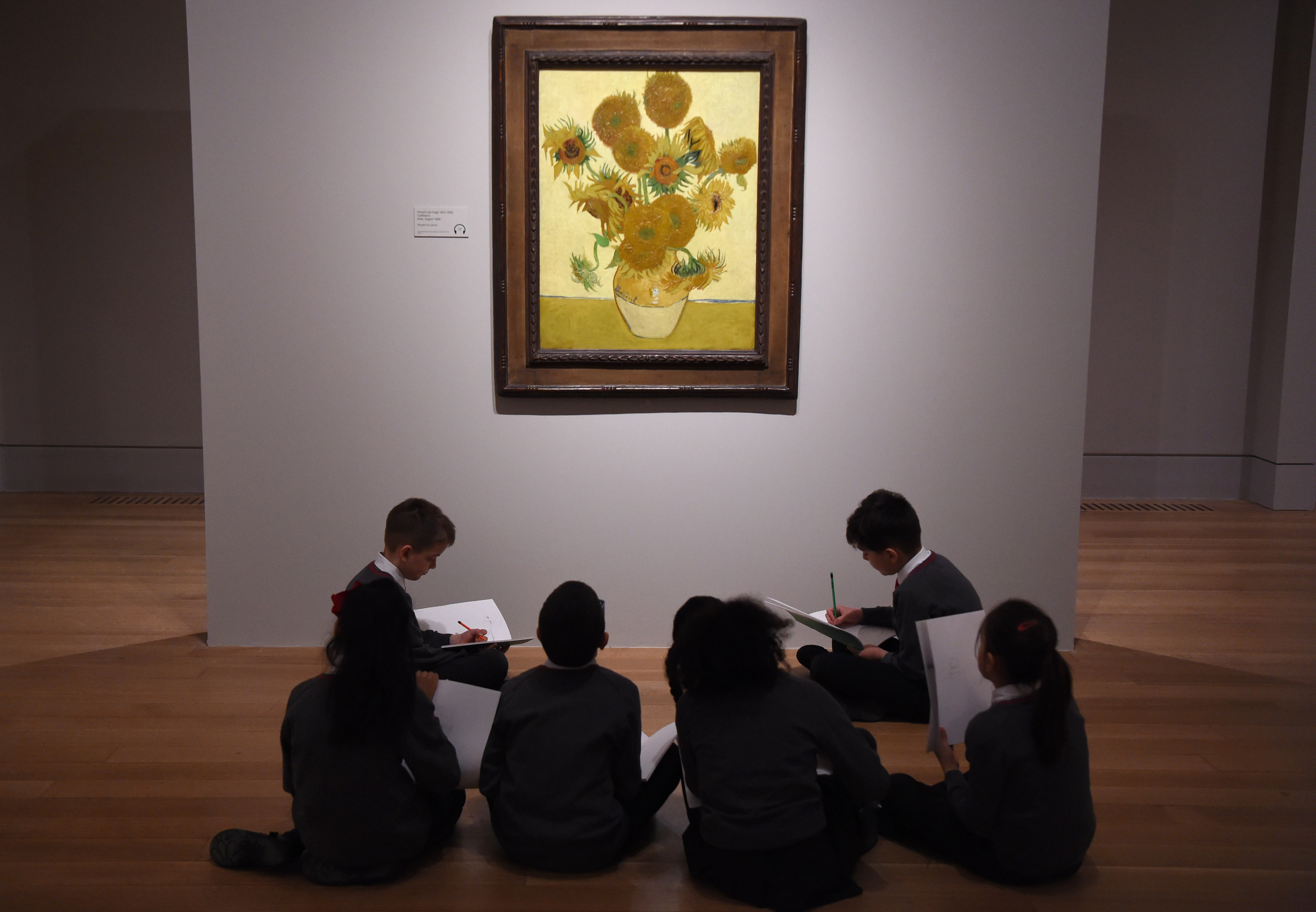 School children study Vincent van Gogh's Sunflowers painting at the EY Exhibition: Van Gogh and Britain press day which opens at Tate Britain on March 25, 2019 in London, United Kingdom.