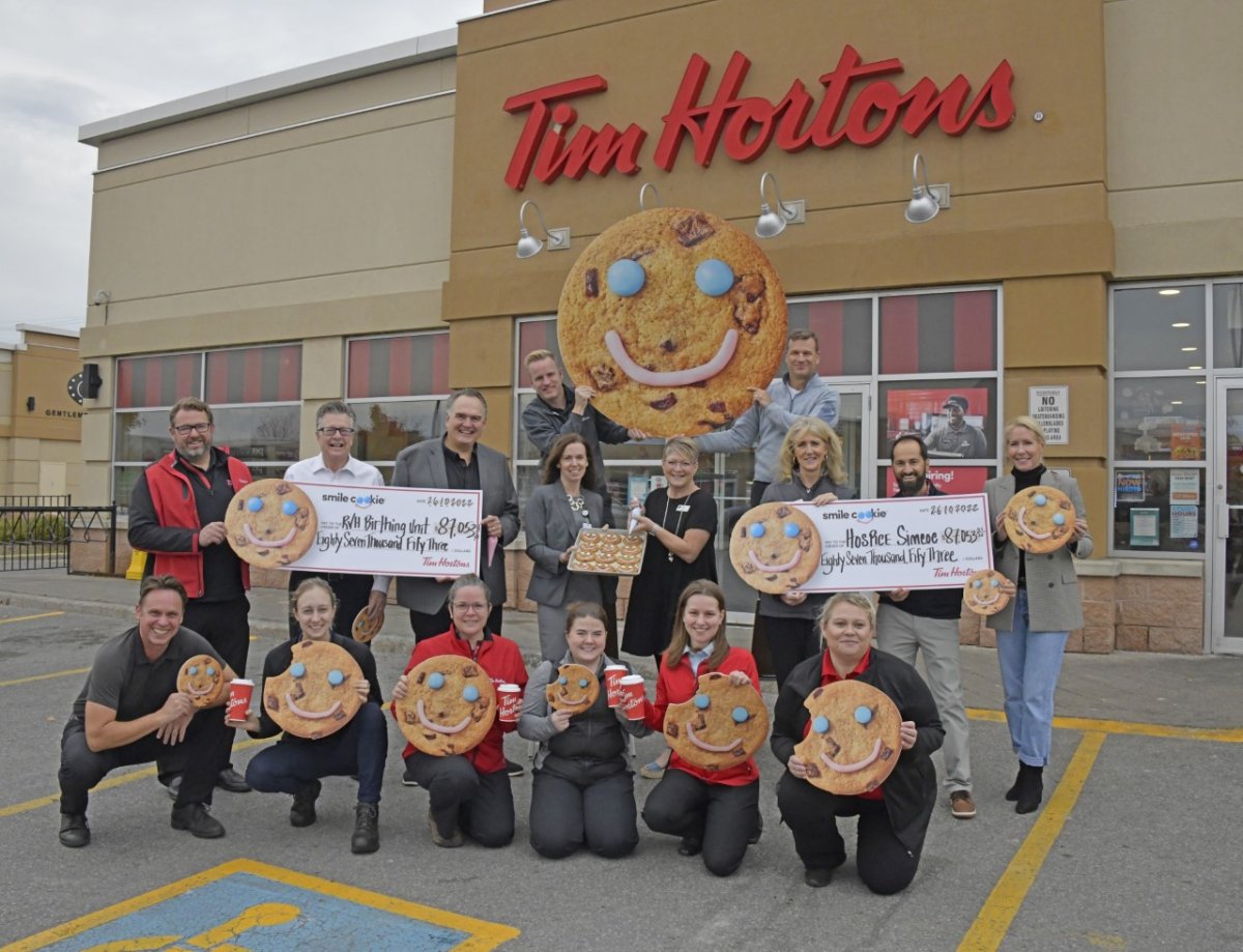 Kelly Hubbard, (middle centre, right), is joined by Gail Hunt (middle centre, left), Marilyn Guest,(middle, third from right), and Paul Larche, (middle, third from left), as well as Barrie and Stroud Tim Hortons restaurant owners and staff (from top left to right: Brandon Newlove, Jason Holman, Geoff House, Mark Hinton, Johnny Mizzoni and Susan Holman, bottom left to right: Paul Stevenson, Sarah Hinton, Dawn Melling, Lauren Melling, Lianne Melling and Tammy Hughes to celebrate the incredible success of the Tim Hortons Smile Cookie Campaign benefiting Hospice Simcoe and RVH's Birthing Unit.
