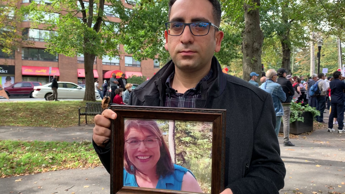 Reza Rahimi holds up a picture of his mother-in-law, Shari Faghihi, who was killed in the Iran plane crash in 2020.