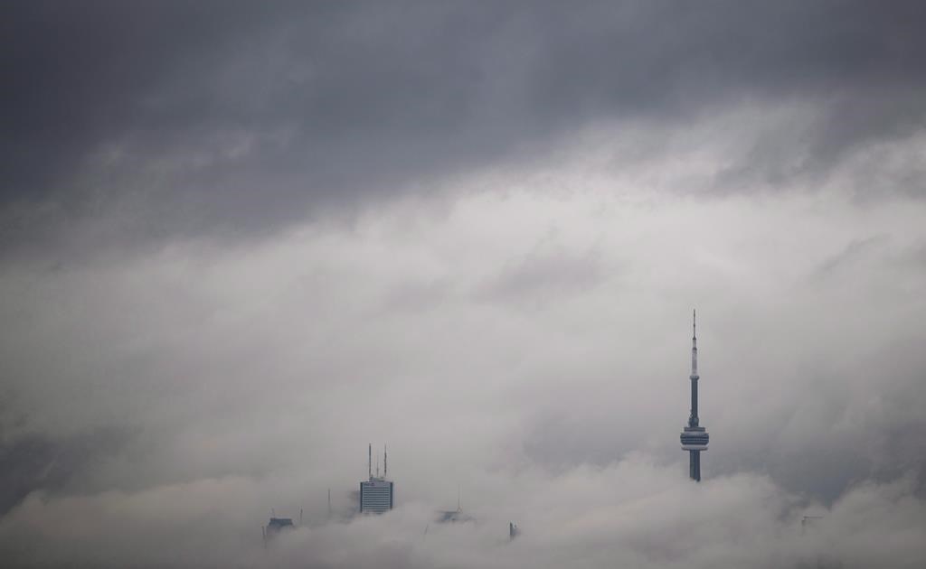 Environment Canada is warning of near zero visibility and hazardous driving conditions in a fog advisory for parts of Ontario. Fog rolls in front of the CN Tower and skyline in Toronto, Friday May 13, 2016. 