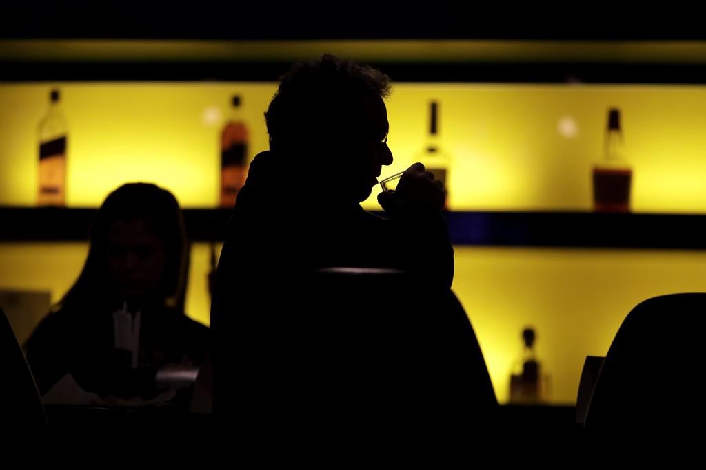 In this file photo, a patron sips his drink while having a meal at a bar. Calgary police have laid additional charges against a man who was previously charged in the 2022 sexual assault of his employee.