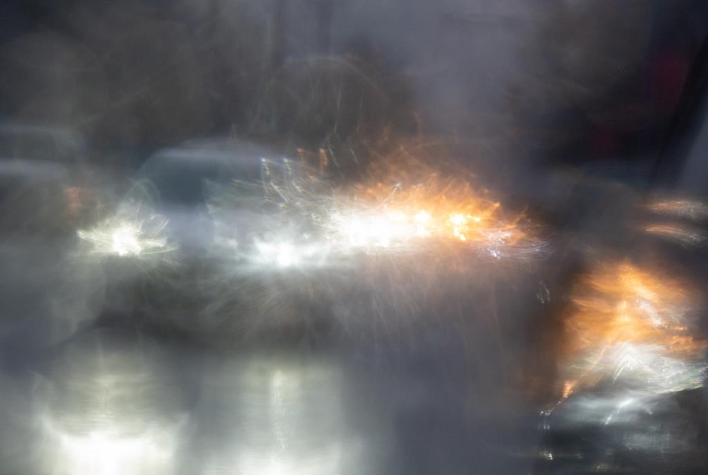 Traffic is reflected in a rain covered car mirror as cars move through heavy rain in Vancouver, Wednesday, Jan. 12, 2022.