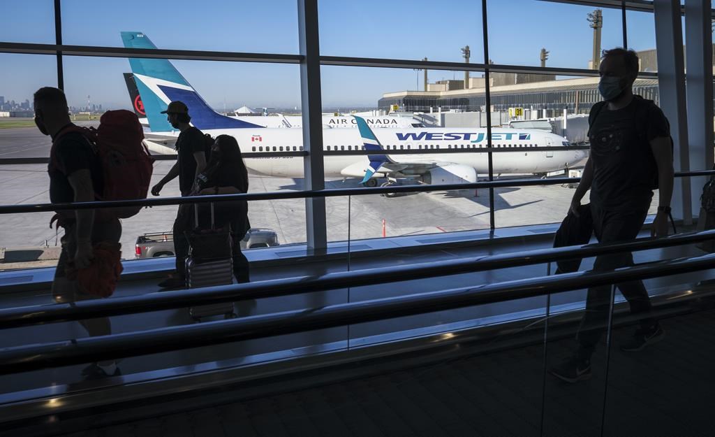 Passengers walk at Calgary International Airport in Calgary, Alta., Wednesday, Aug. 31, 2022.