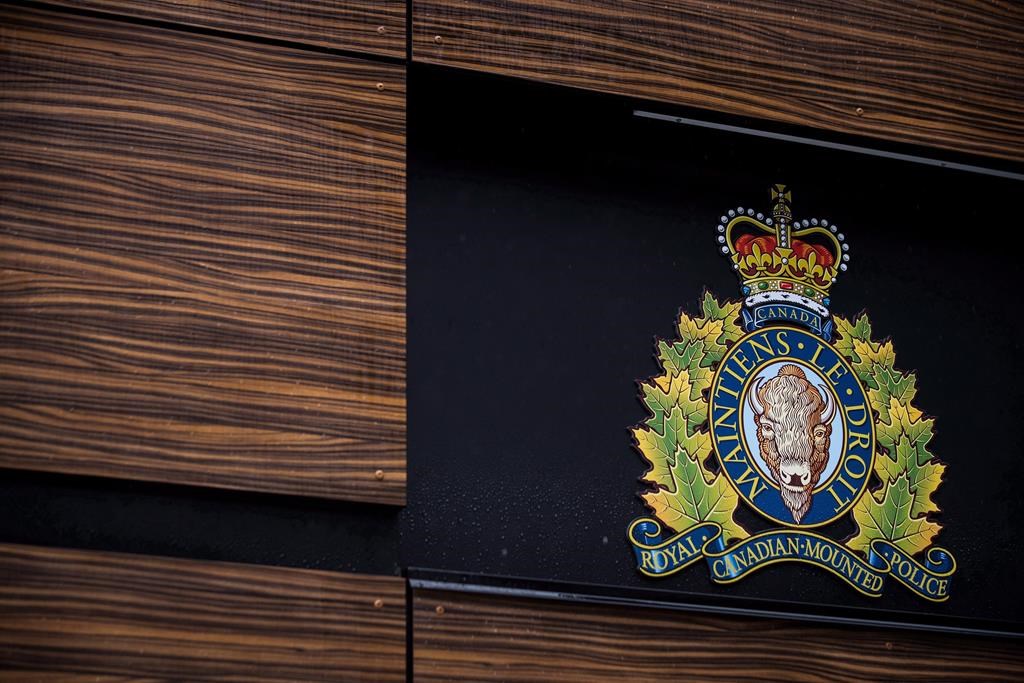 The RCMP logo is seen outside Royal Canadian Mounted Police "E" Division Headquarters, in Surrey, B.C., on Friday April 13, 2018. Cochrane RCMP arrested three people with firearms trafficking charges after a string of break-and-enters in the town. THE CANADIAN PRESS/Darryl Dyck.