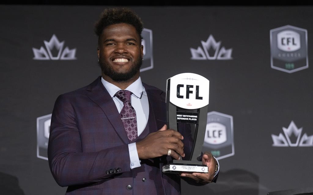 Most outstanding defensive player, defensive lineman Lorenzo Mauldin IV of the Ottawa Redblacks, holds up his trophy during the CFL Awards in Regina, Thursday, Nov. 17, 2022. THE CANADIAN PRESS/Paul Chiasson