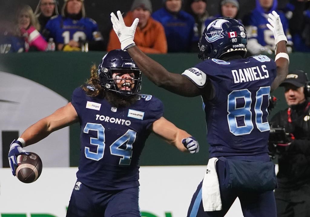 Toronto Argonauts running back AJ Ouellette (34) celebrates his touchdown with wide receiver DaVaris Daniels (80) during second half football action against the Winnipeg Blue Bombers in the 109th Grey Cup at Mosaic Stadium in Regina, Sunday, Nov. 20, 2022. Ouellette's five-yard touchdown run in the fourth quarter rallied the Toronto Argonauts to a stirring 24-23 upset of the Winnipeg Blue Bombers in the 109th Grey Cup on Sunday night. THE CANADIAN PRESS/Heywood Yu.