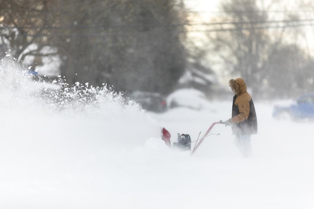 A man uses a snowblower in Fort Erie, Ont., during an early winter storm that delivered high winds and large amounts of snow across southern Ontario and western New York, Saturday, Nov. 19, 2022. THE CANADIAN PRESS/Nick Iwanyshyn.