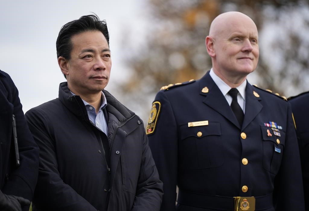 Vancouver Mayor Ken Sim, left, and Vancouver Police Chief Adam Palmer listen as B.C. Premier David Eby announces a new public safety plan in Vancouver on Sunday, November 20, 2022.
