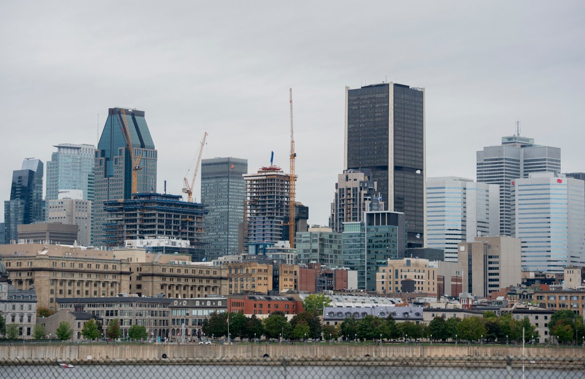 Cranes are shown next to the Montreal skyline, Sunday, October 3, 2021. 
