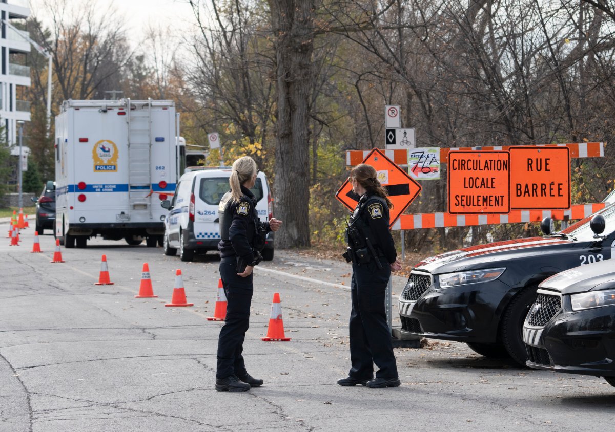 Police seal off the site where a missing one-month-old baby was found after a car crashed into the water of the Milles-Iles river three days ago, in Laval, Que., Monday, Oct. 31, 2022. 