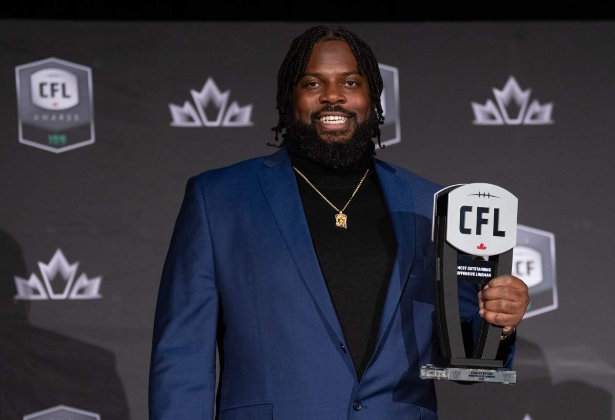 Most outstanding offensive linesman, offensive linesman Stanley Bryant of the Winnipeg Blue Bombers, holds up his trophy during the CFL Awards in Regina, Thursday, Nov. 17, 2022.