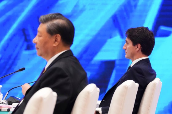 Prime Minister Justin Trudeau and Chinese President Xi Jinping sit at a table at the APEC summit