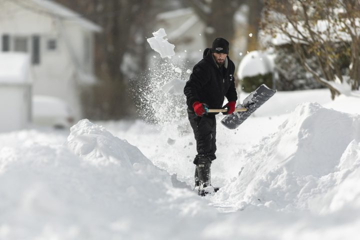 A man shovels a path to his house in Fort Erie, Ont., during an early winter storm that delivered high winds and large amounts of snow across southern Ontario and western New York, Saturday, Nov. 19, 2022. 