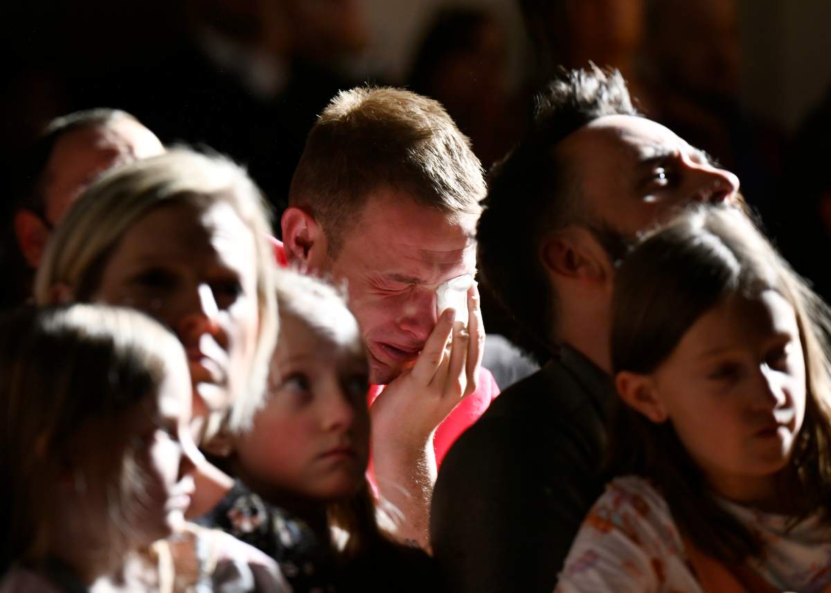 R.J. Lewis, center, attends a vigil at All Souls Unitarian Church with others, Sunday, Nov. 20, 2022, in Colorado Springs, Colo., following a fatal shooting at gay nightclub Club Q late the night before. Lewis was at Club Q when a 22-year-old gunman entered the LGBTQ nightclub killing several people and injuring multiple others.
