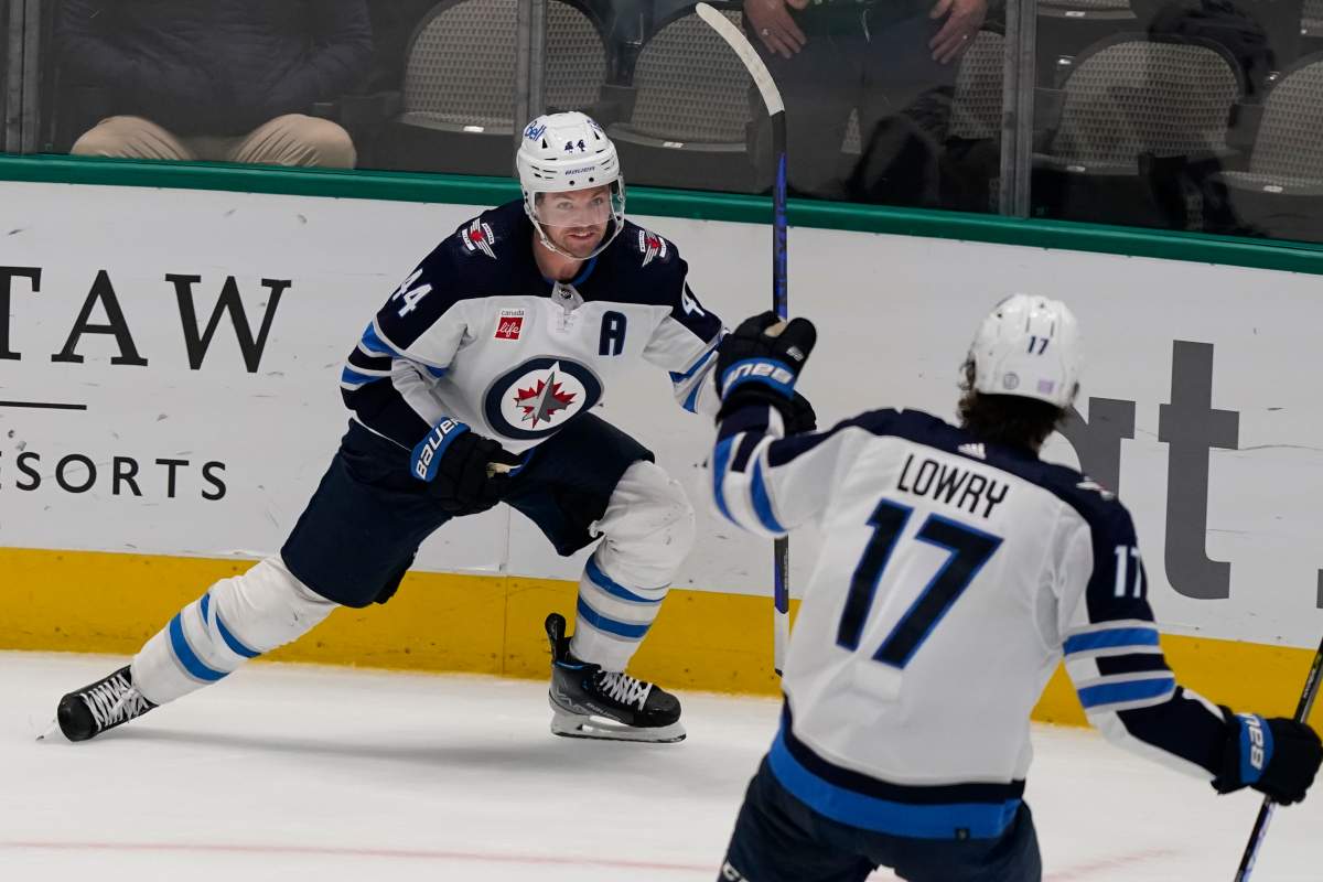 The Winnipeg Jets’ Josh Morrissey (44) celebrates scoring a goal with teammate Adam Lowry (17) during overtime in an NHL hockey game against the Dallas Stars in Dallas, Friday, Nov. 25, 2022. The Jets won 5-4.