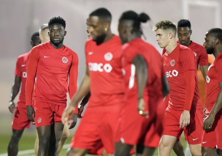 Canada forward Alphonso Davies, left, warms up with teammates during practice at the World Cup in Doha, Qatar on Tuesday, November 29, 2022.