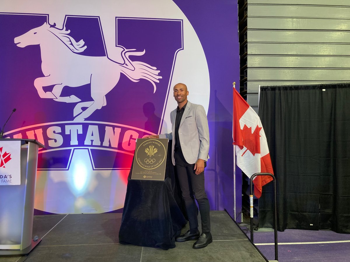 London, Ont.-born Olympic gold medallist Damian Warner next to his hometown Canada's Walk of Fame plaque at Western University’s Thompson Arena on Monday, Nov. 14, 2022.