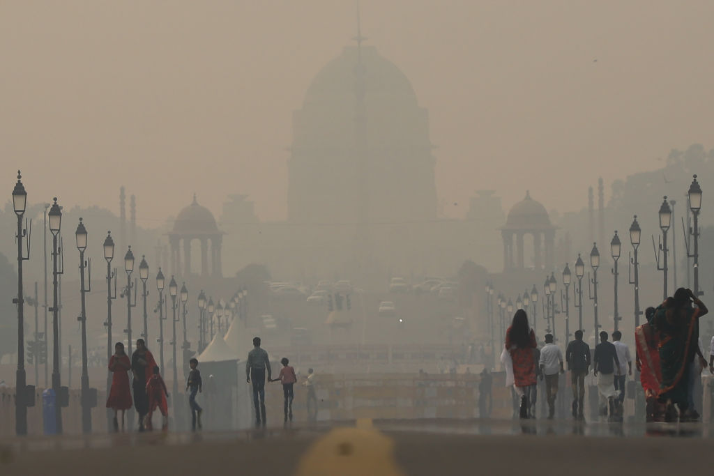 Commuters make their way past the presidential palace amid smoggy conditions in New Delhi on November 03, 2022.