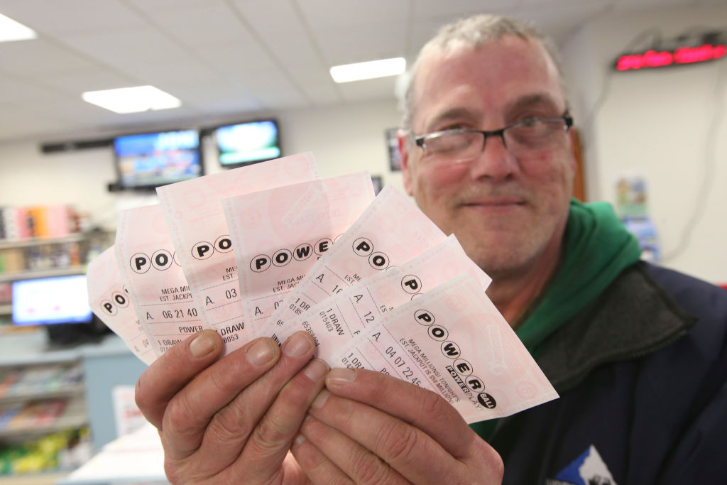 File - Stephen Joyce, of Dorchester, holds his Powerball tickets at The Hub on Broadway on Friday, March 22, 2019 in Boston, Massachusetts.
