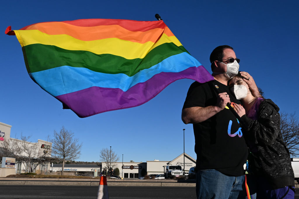 Alex Clemons, left, and his daughter Epifania, 11, hug while paying their respects at a makeshift memorial near Club Q on November 20, 2022 in Colorado Springs, Colorado.