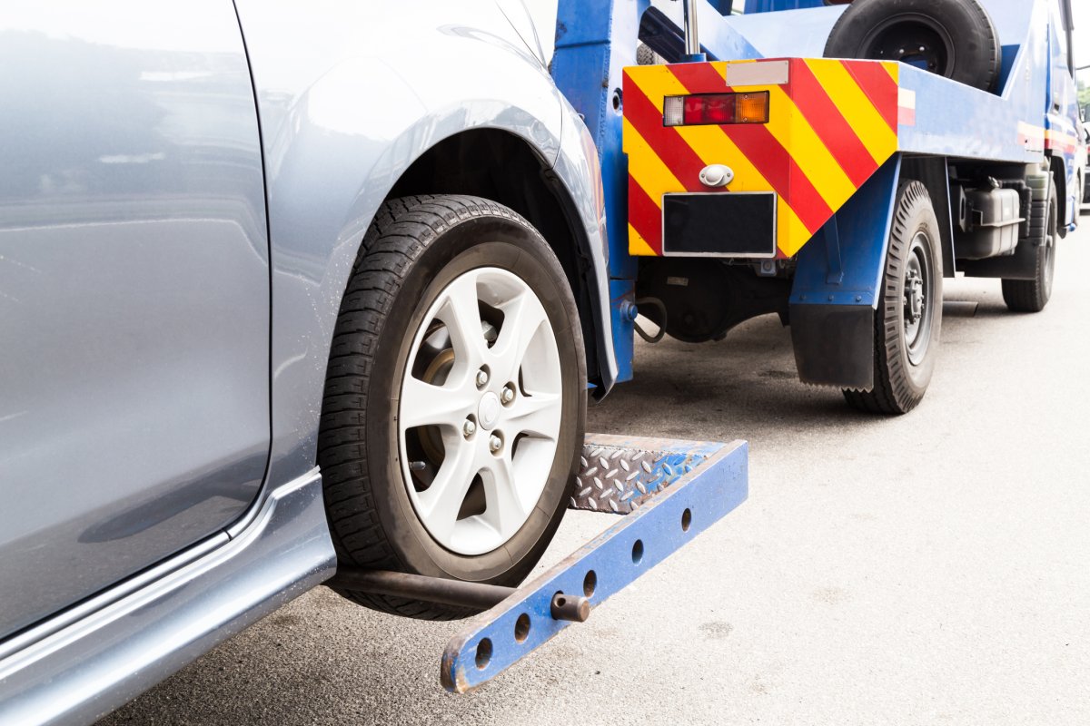 File image - a vehicle is prepared for towing by a tow truck.