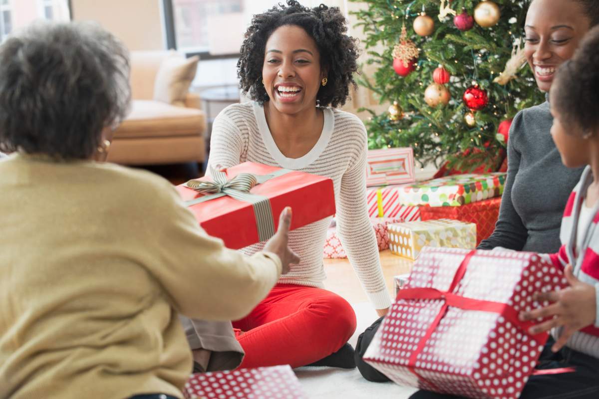 People exchanging red-wrapped Christmas gifts