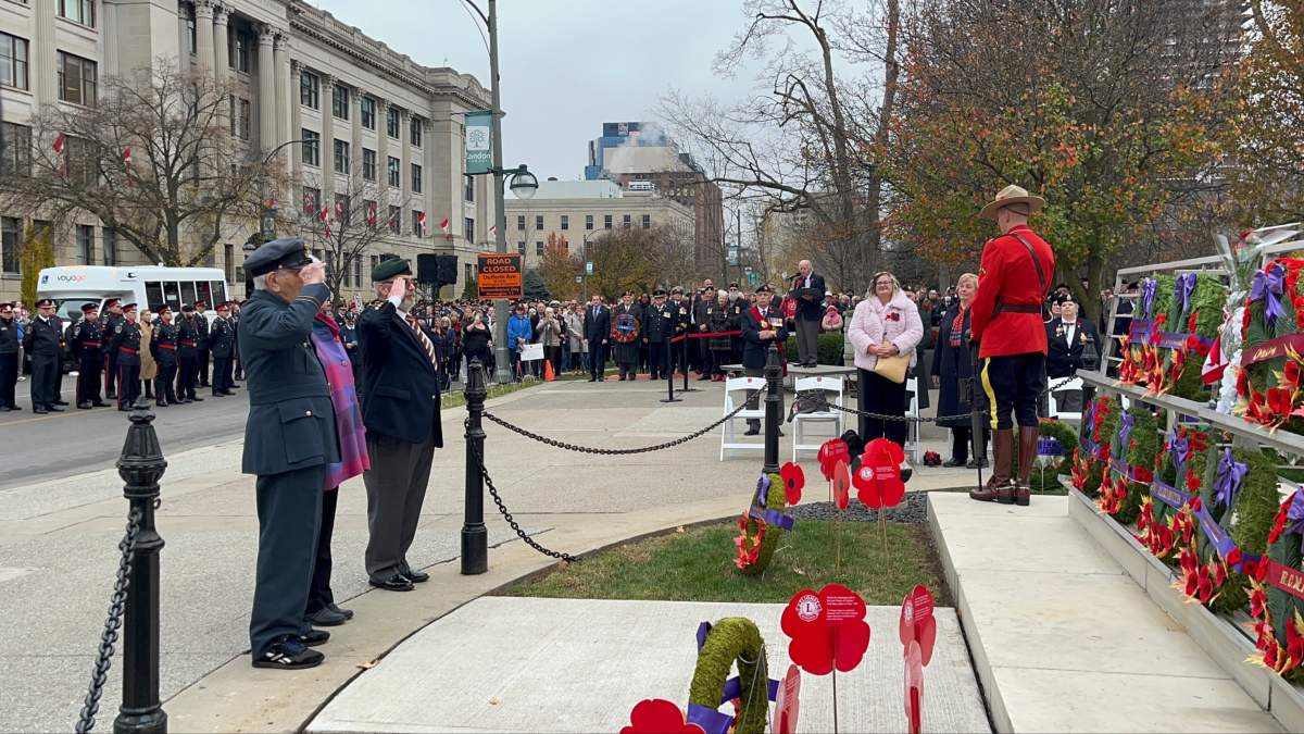 This year's honorary veteran Tom Hennessy (left, nearside) salutes in front of the Cenotaph in Victoria Park after laying a wreath on behalf of all the Royal Canadian Legion and all veterans.