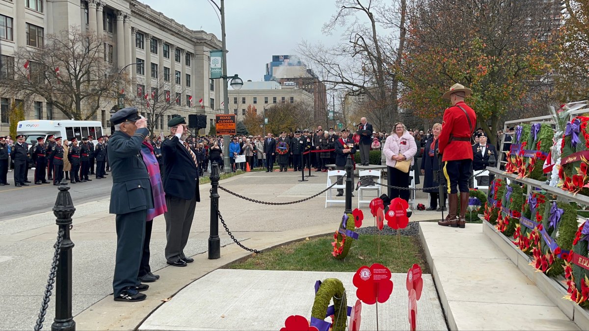 This year's honorary veteran Tom Hennessy (left, nearside) salutes in front of the Cenotaph in Victoria Park after laying a wreath on behalf of all the Royal Canadian Legion and all veterans.