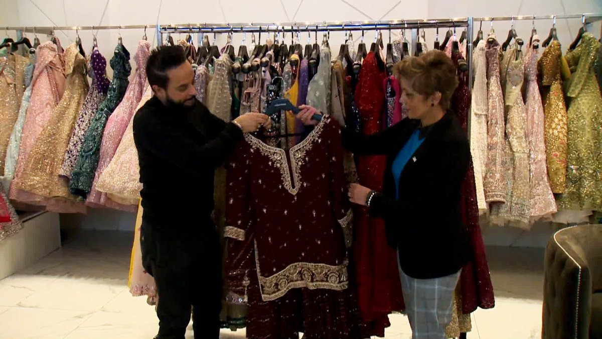 Calgary Mayor Jyoti Gondek (R) examines a dress with Pooja's Boutique owner Bobby Chawala on Nov. 30, 2022, during the kick-off to the city's "Support Local" annual campaign.