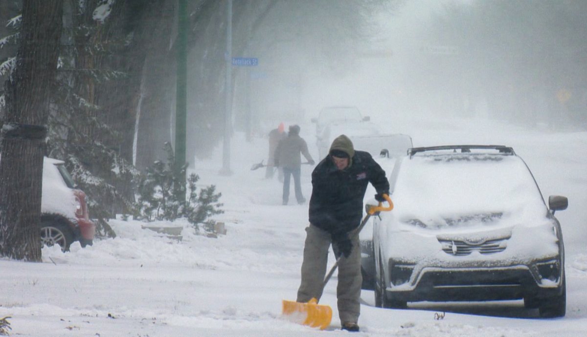 Regina residents can be seen shoveling snow after an Alberta Clipper rolled through the province Sunday morning. 