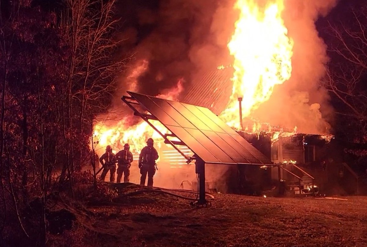 Firefighters tend to a fire on Mountain Road near Westport, Ont.