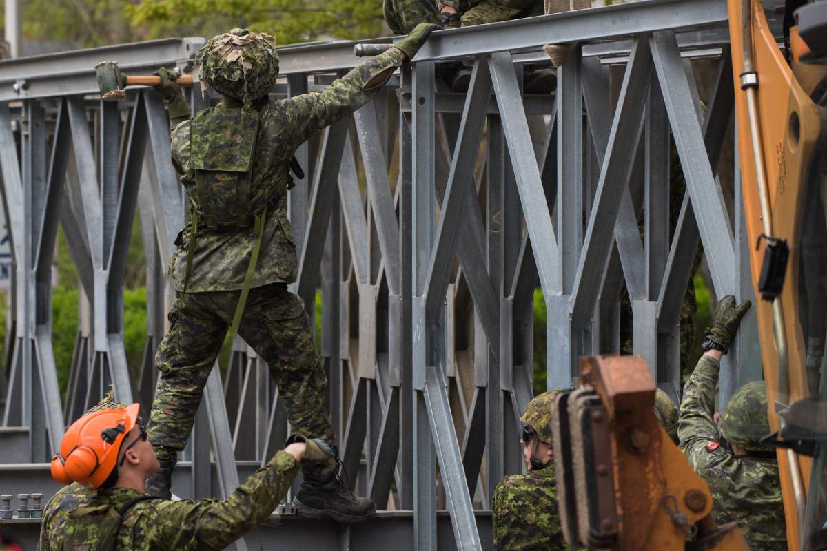 FILE - Members from 5 Combat Engineer Regiment install a temporary bridge at l’île Verte, in Laval in Quebec during Operation LENTUS, May 13, 2017.