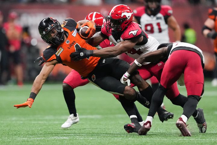 B.C. Lions' Keon Hatcher, front left, is tackled by Calgary Stampeders' Silas Stewart, back right, and Brad Muhammad during the second half of CFL football game in Vancouver, on Saturday, September 24, 2022. 
