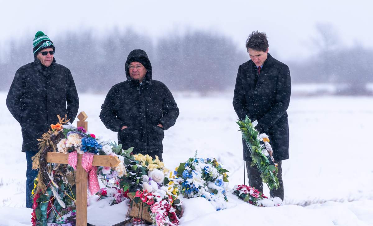 Prime Minister Justin Trudeau pays respects at a grave in James Smith Cree Nation.