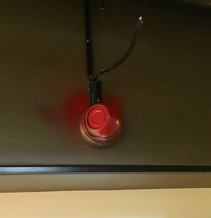 A spray-painted security camera in gallery.