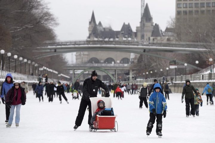 The Chateau Laurier is seen behind skaters on the Rideau Canal Skateway at the Winterlude Festival in Ottawa, Saturday, Jan. 30, 2016. 