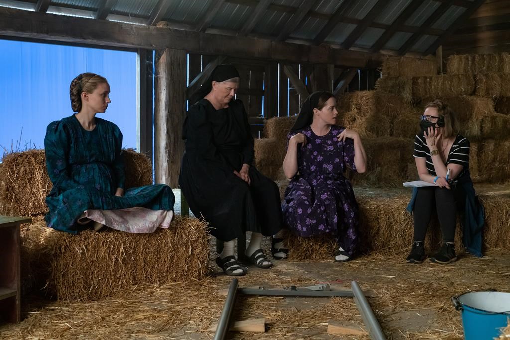 Left to right, actors Rooney Mara, Judith Ivey and Claire Foy and director Sarah Polley talk on the set of their film 'Women Talking' in this undated handout photo.