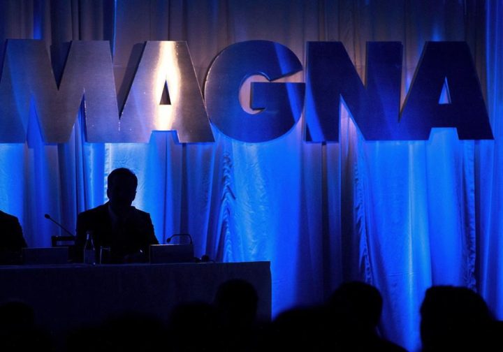 A Magna International Inc. sign is silhouetted at the company's annual general meeting in Toronto on Friday, May 10, 2013.