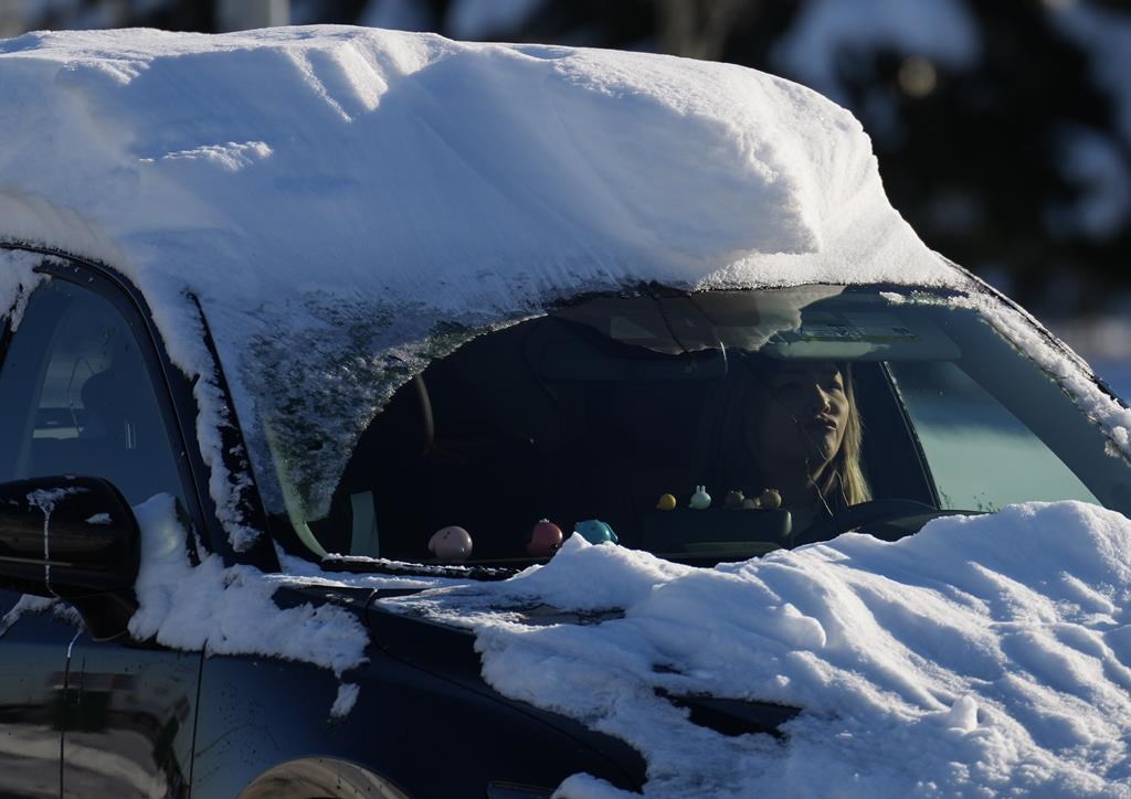 A motorist with snow on their car drives in Richmond, B.C., on Wednesday, Dec. 21, 2022. Warmer weather is set to arrive in parts of British Columbia by Christmas Eve but forecasters warn it's going to get messy. THE CANADIAN PRESS/Darryl Dyck.