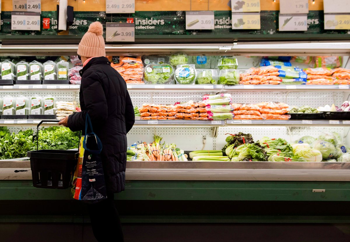 A file photo of a woman overlooking produce in a grocery store.