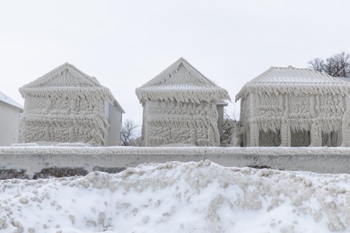 Houses along the shores of Lake Erie, near Fort Erie, Ont., remain covered in ice Tuesday, December 27, 2022, following a winter storm that swept through much of Ontario.