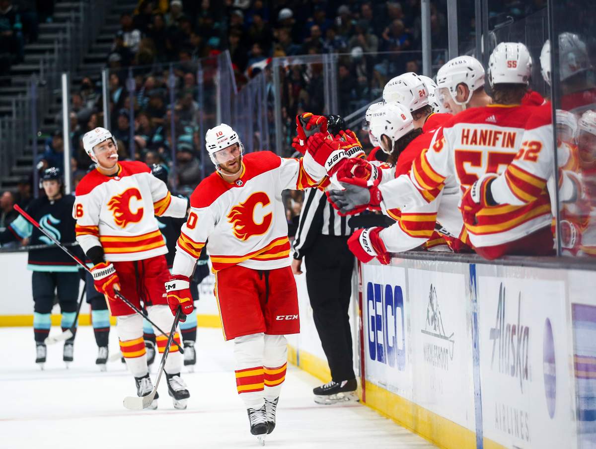 Calgary Flames center Jonathan Huberdeau (10) is congratulated for his go-ahead goal against the Seattle Kraken during the third period of an NHL hockey game Wednesday, Dec. 28, 2022, in Seattle.