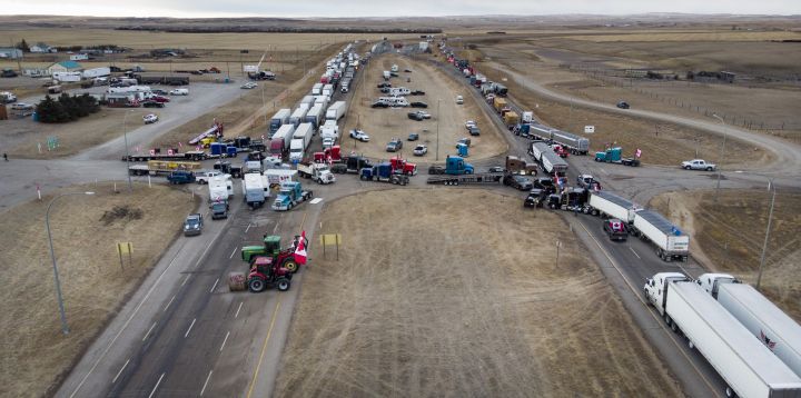 Anti-COVID-19 vaccine mandate demonstrators gather as a truck convoy blocks the highway at the busy U.S. border crossing in Coutts, Alberta, Canada, Monday, Jan. 31, 2022.