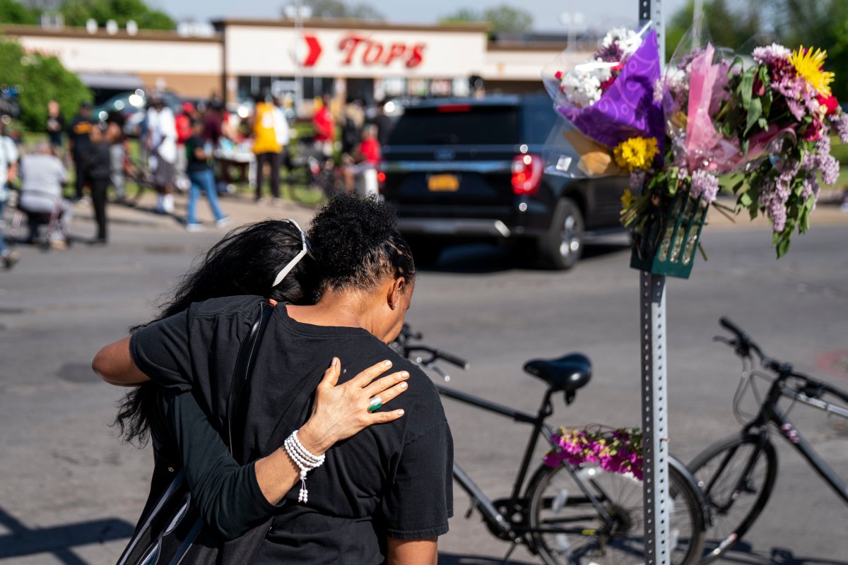 Two women hug at the scene of a mass shooting at Tops Friendly Market in Buffalo, N.Y.