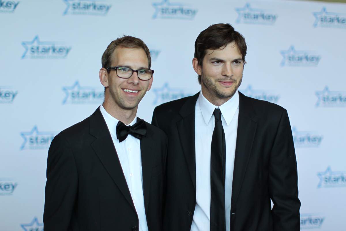 Ashton and Michael Kutcher stand on a red carpet.
