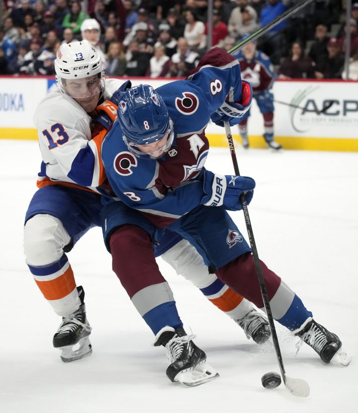 New York Islanders centre Mathew Barzal, left, tangles with Colorado Avalanche defenceman Cale Makar in overtime during an NHL hockey game Monday, Dec. 19, 2022, in Denver.