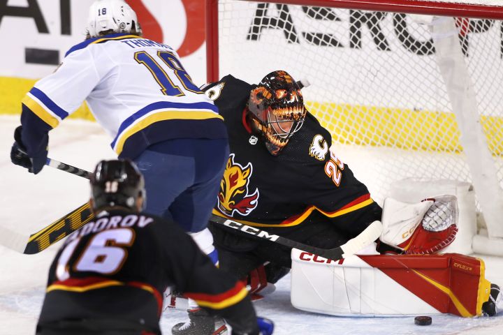 Calgary Flames goalie Jacob Markstrom, makes a save against St. Louis Blues’ Robert Thomas during first period NHL hockey action in Calgary, Friday, Dec. 16, 2022.